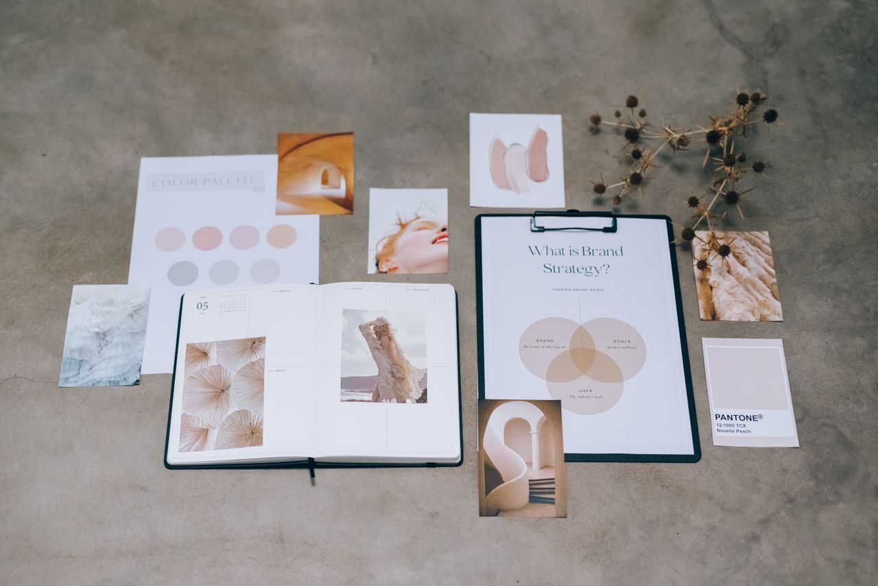 Une composition à plat d’éléments de branding avec des palettes de couleurs et des documents de planification stratégique posés sur une surface en béton.